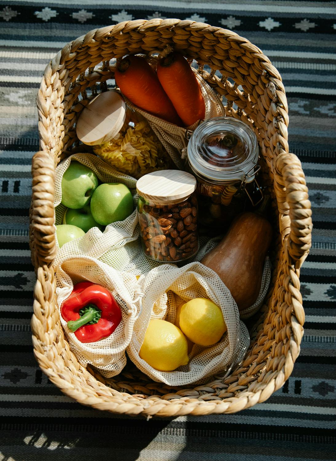 Fresh vegetables and wellness products arranged on a table outdoors in bright sunlight, symbolizing healthy eating and nutrient-rich living.