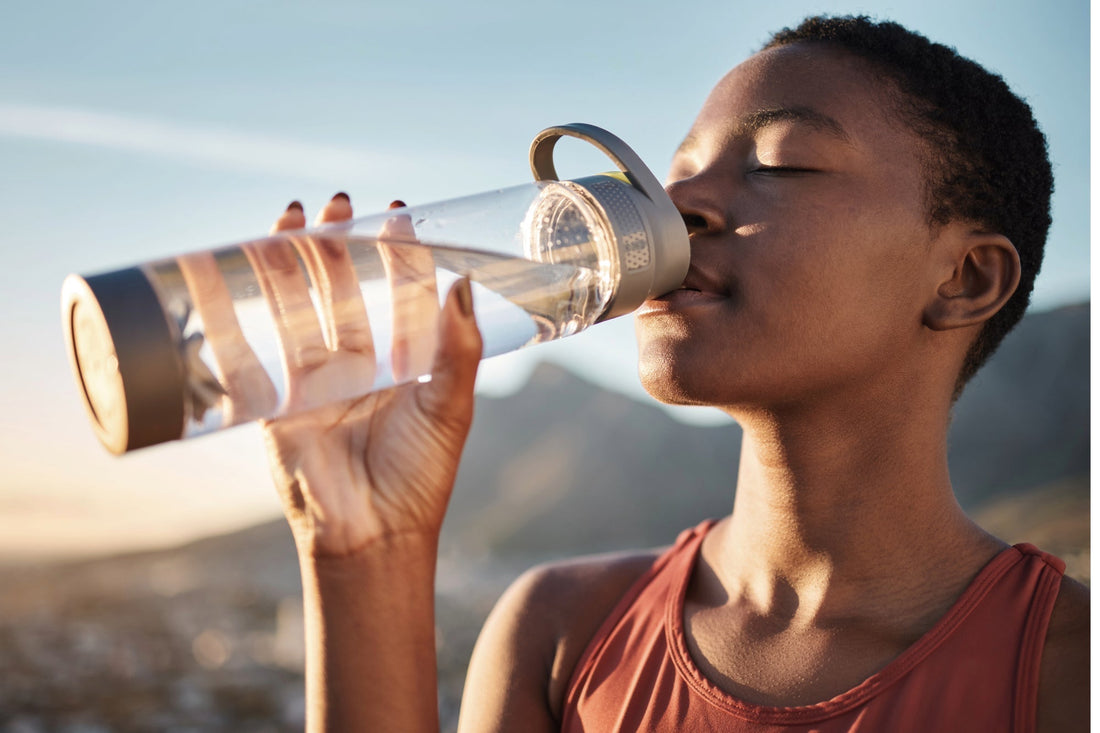 A woman drinks water enhanced with a squeeze of Buoy to stay hydrated with POTS.