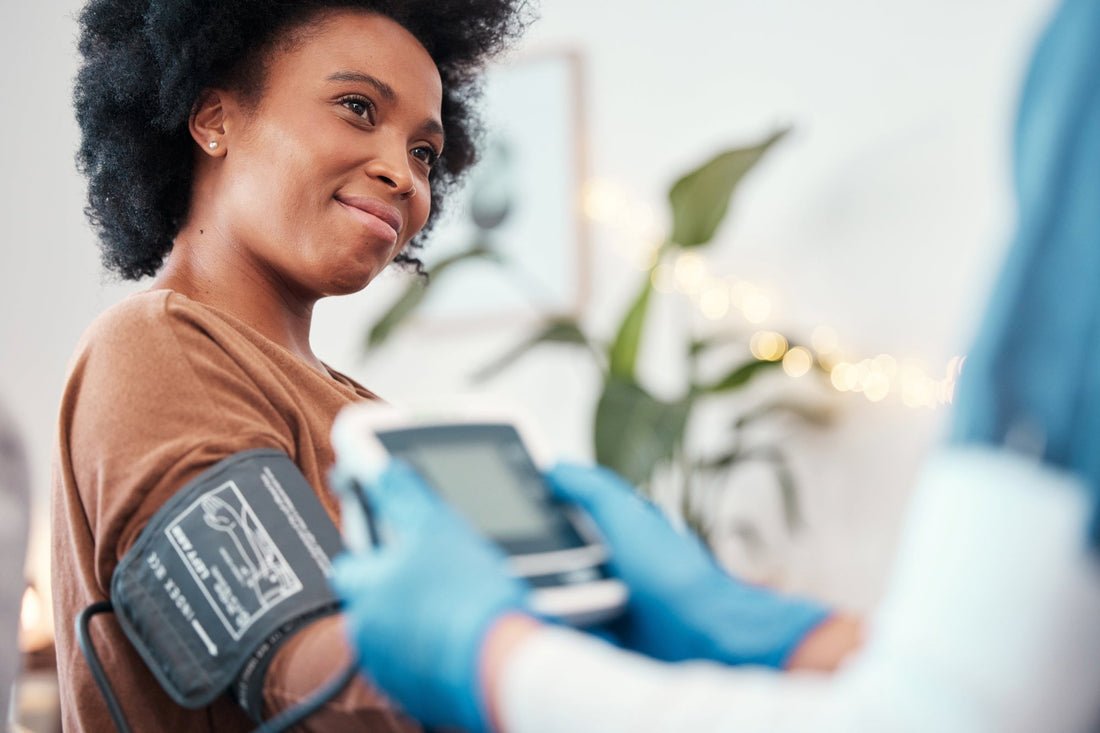 A healthcare professional measures a woman’s blood pressure during a routine checkup, highlighting the importance of monitoring cardiovascular health POTS.