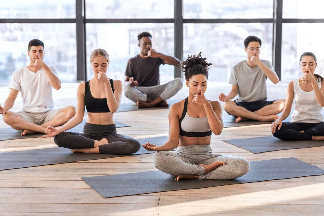 A group practicing breathing exercises in a yoga class, focusing on calming techniques to support relaxation and stress relief.
