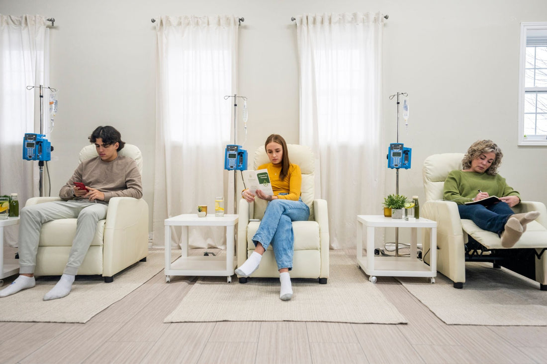 Three people receive IV fluid for POTS in a hydration clinic.