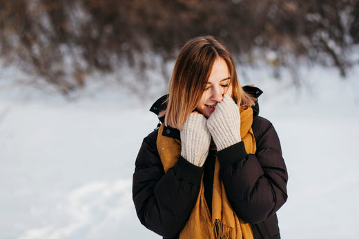 Woman standing outsite in snow and smiling.