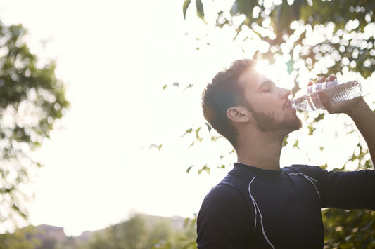 Man drinking water to stay hydrated and get electrolytes.
