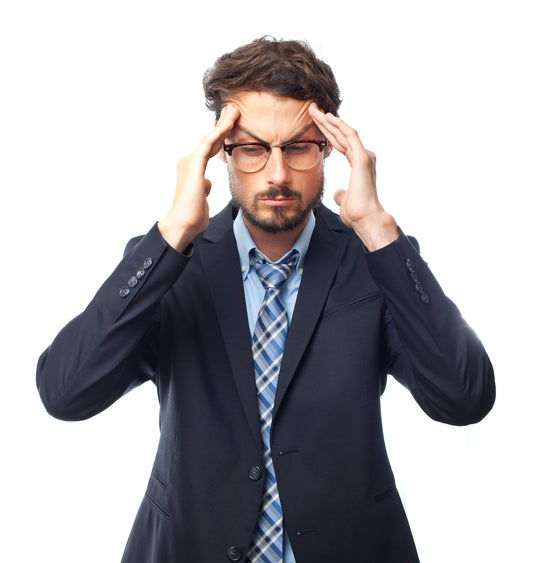 Stressed man in business attire holding his head, symbolizing brain fog and mental fatigue