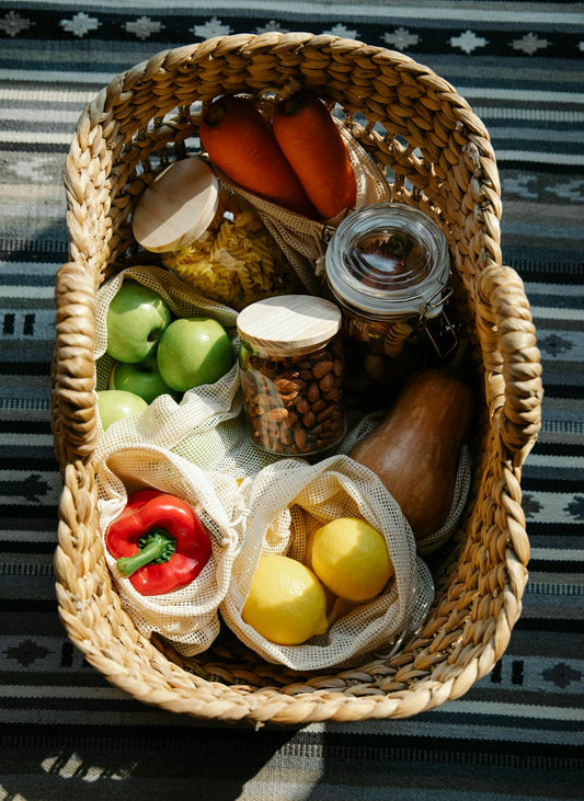 Fresh vegetables and wellness products arranged on a table outdoors in bright sunlight, symbolizing healthy eating and nutrient-rich living.
