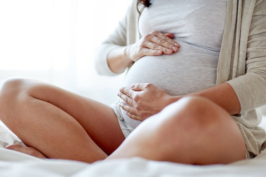 Pregnant woman resting her hands on her belly, representing the journey of managing POTS symptoms during pregnancy.