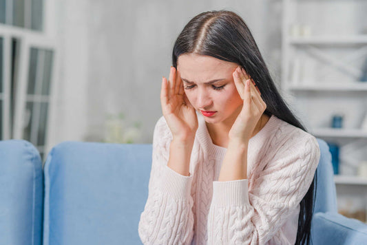 female pressing both temples with a migraine headache.