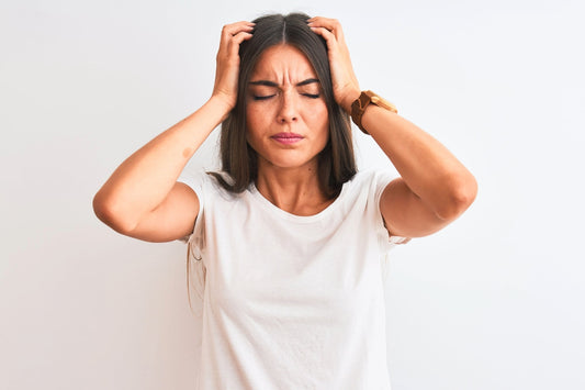 A woman holds her head as she suffers from POTS brain fog.
