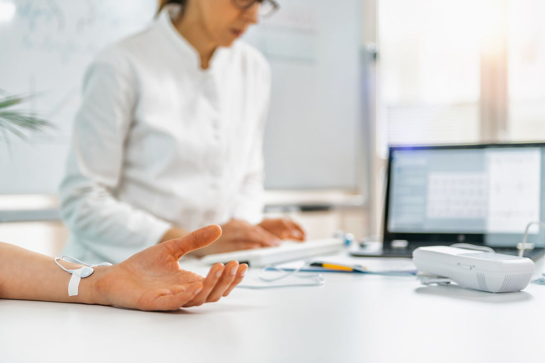 A healthcare professional monitors a patient's vital signs during a biofeedback session for treating POTS.