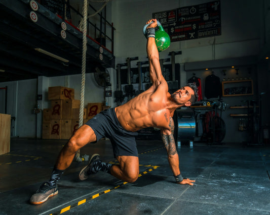 Athlete performing kettlebell exercise in gym to improve strength and hydration recovery.