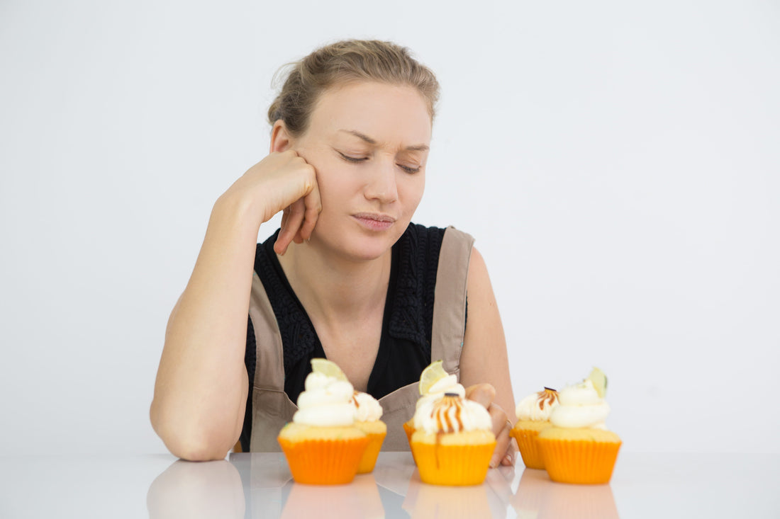 Woman considering sweet foods, illustrating how certain foods may act as migraine food triggers