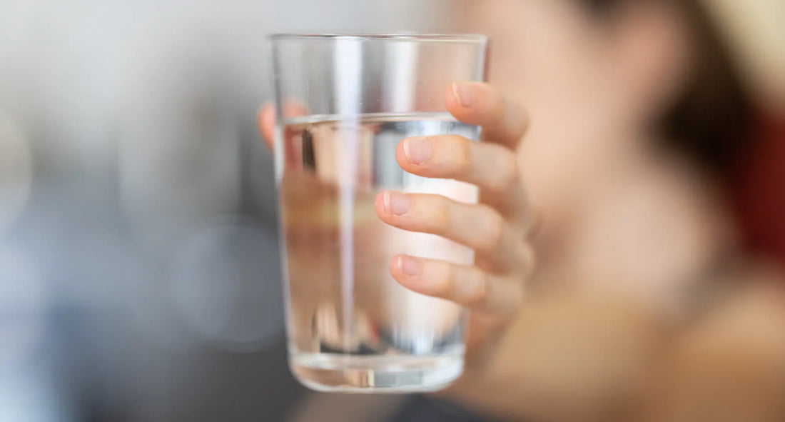a woman holding a glass of water