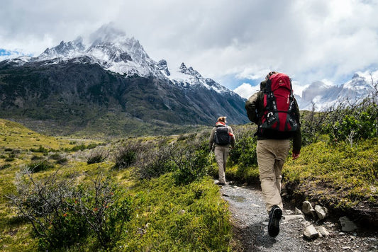 hikers climbing a mountain with snow on the tips