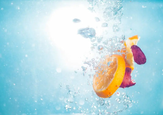 Lemons and berries dropped into water.