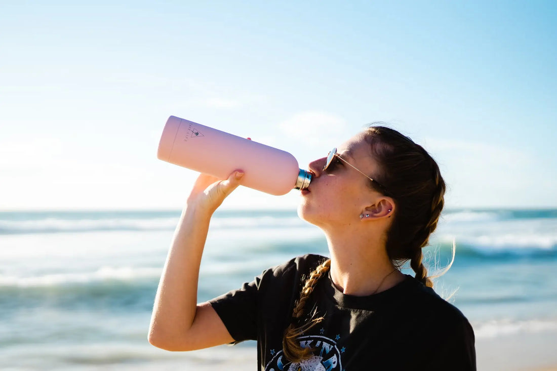 Woman drinking from a water bottle after a workout.