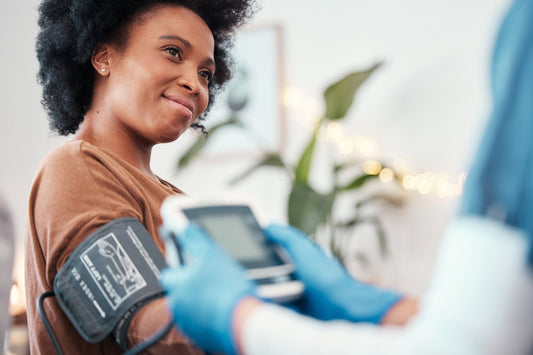 A healthcare professional measures a woman’s blood pressure during a routine checkup, highlighting the importance of monitoring cardiovascular health POTS.