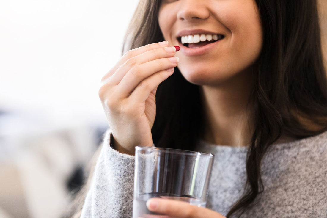 A woman takes a vitamin to help manage her POTS symptoms.