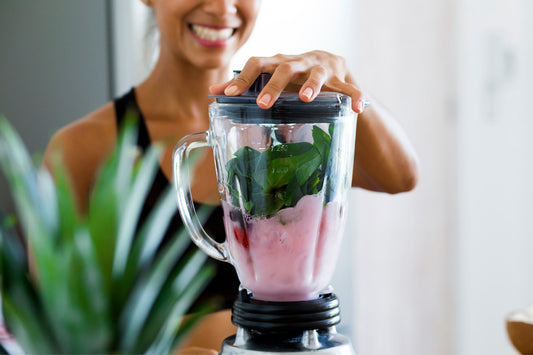 A woman makes a healthy smoothie with fruits and vegetables to help manage her POTS symptoms.