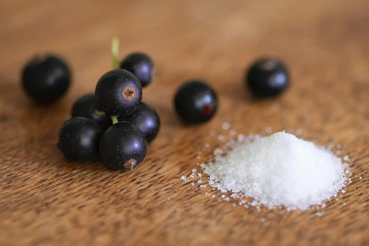a pile of salt next to grapes on a wood table