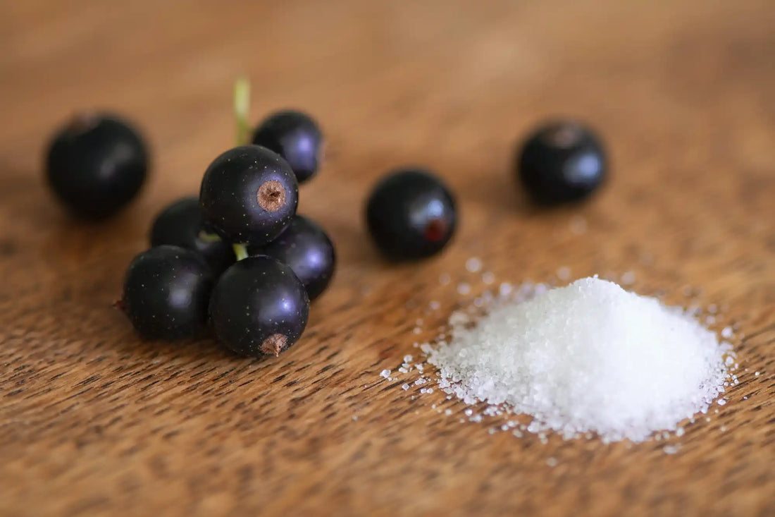 a pile of salt next to grapes on a wood table