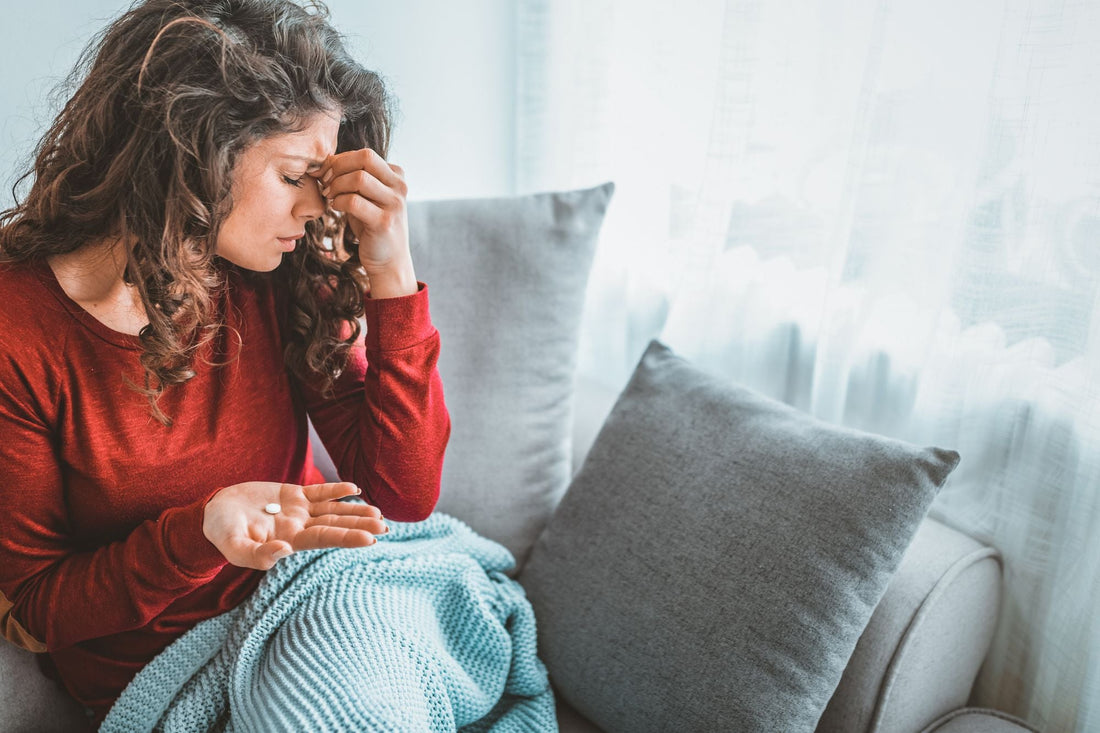 Woman experiencing migraine symptoms considering supplement options.
