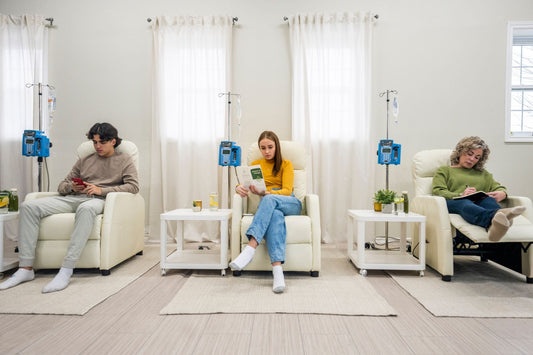 Three people receive IV fluid for POTS in a hydration clinic.