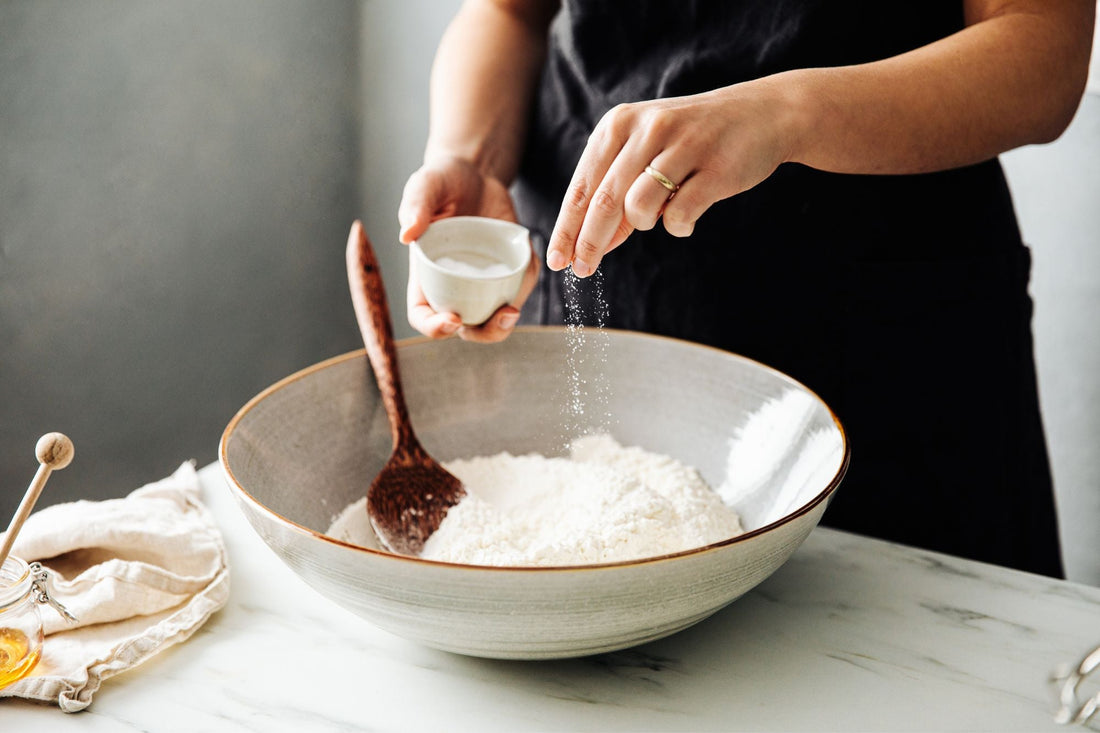 A woman adds high-quality sea salt to her recipe to help manage her POTS symptoms.