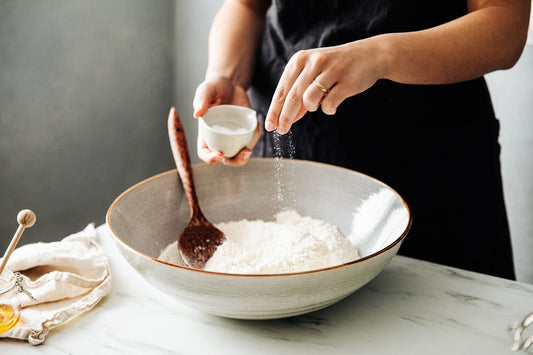 A woman adds high-quality sea salt to her recipe to help manage her POTS symptoms.