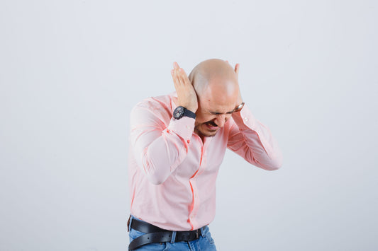 Man holding his head in pain during a severe migraine attack – can migraine cause brain tumor concern concept