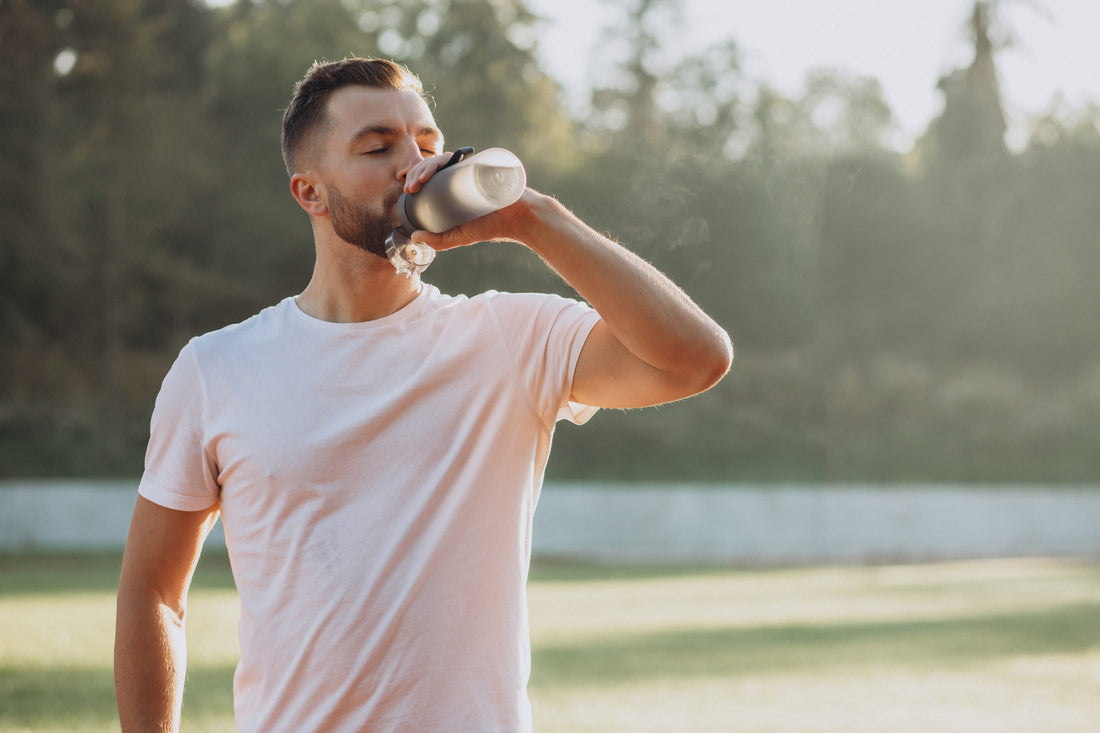 Young sportsman drinking water with electrolytes after exercise.